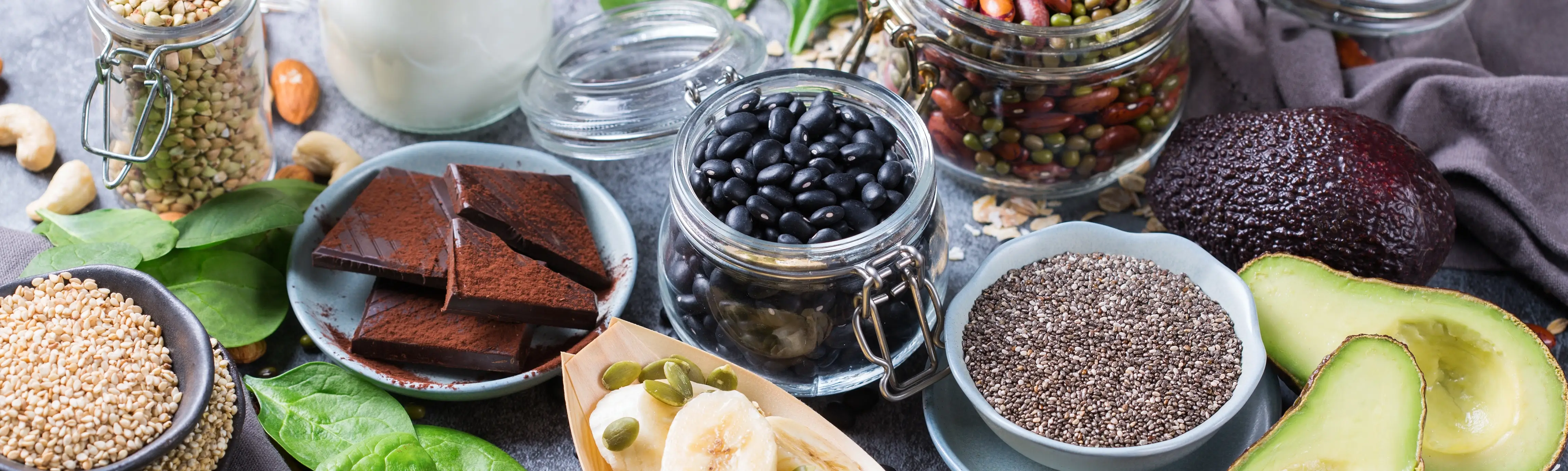 Leafy greens, nuts, and seeds arranged as natural sources of magnesium